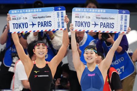 競泳五輪代表選考会の女子１００メートルバタフライでパリ五輪代表に決まり、ボードを掲げる優勝した平井瑞希（右）と２位の池江璃花子＝１８日、東京アクアティクスセンター（共同）