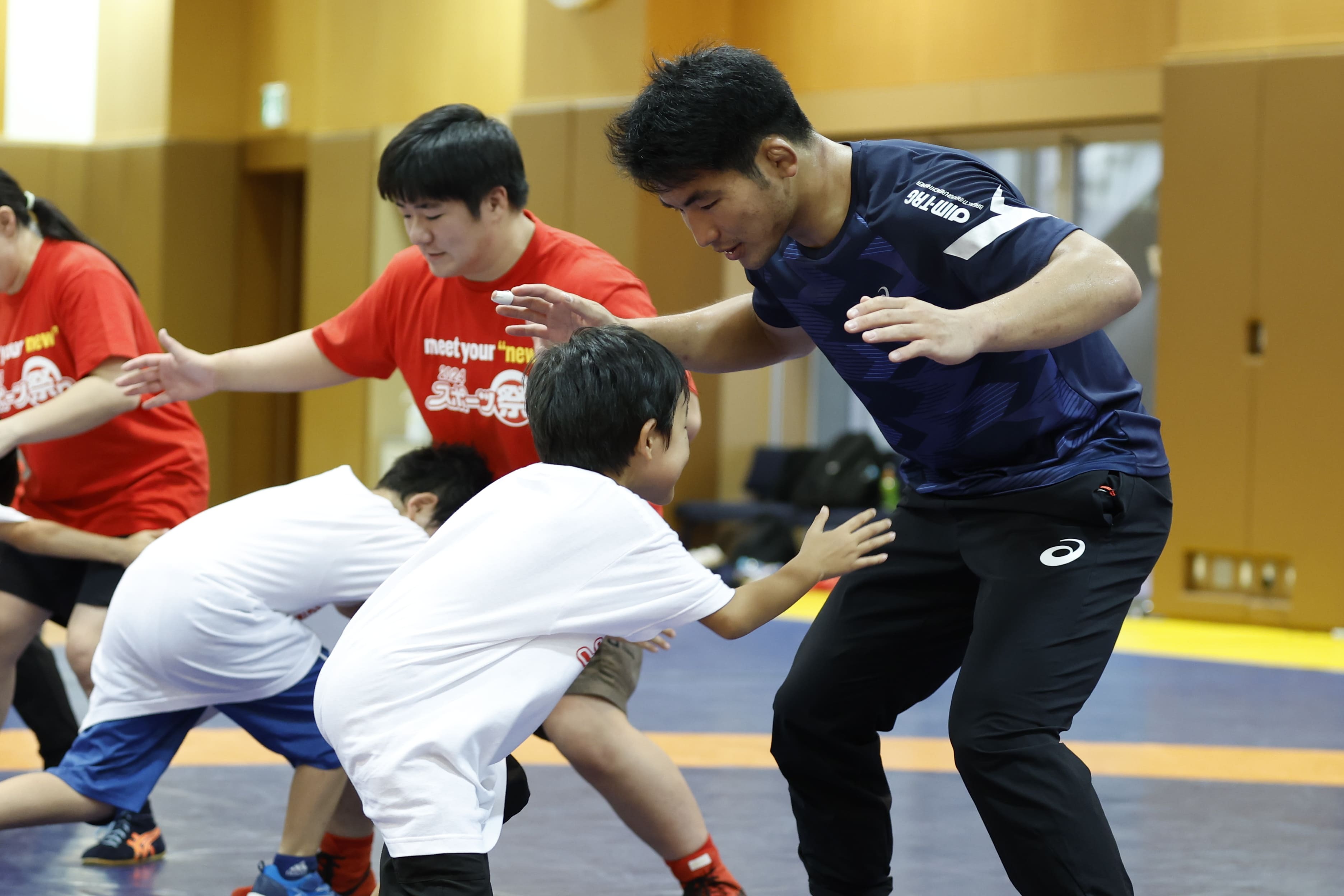 石黒隼士選手にタックルする子ども達（写真：フォート・キシモト）