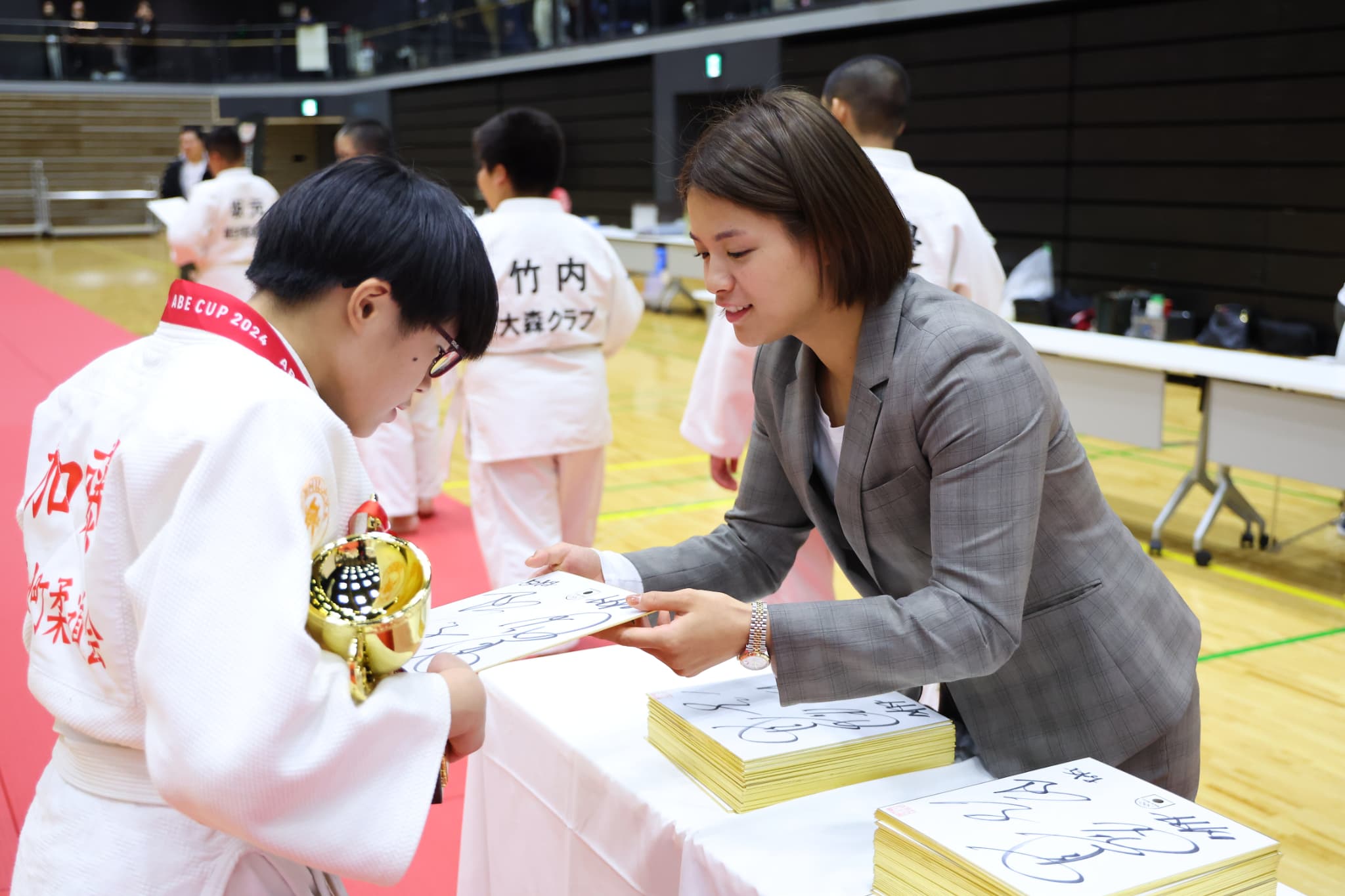 記念品を手渡す阿部詩選手（写真：アフロスポーツ）