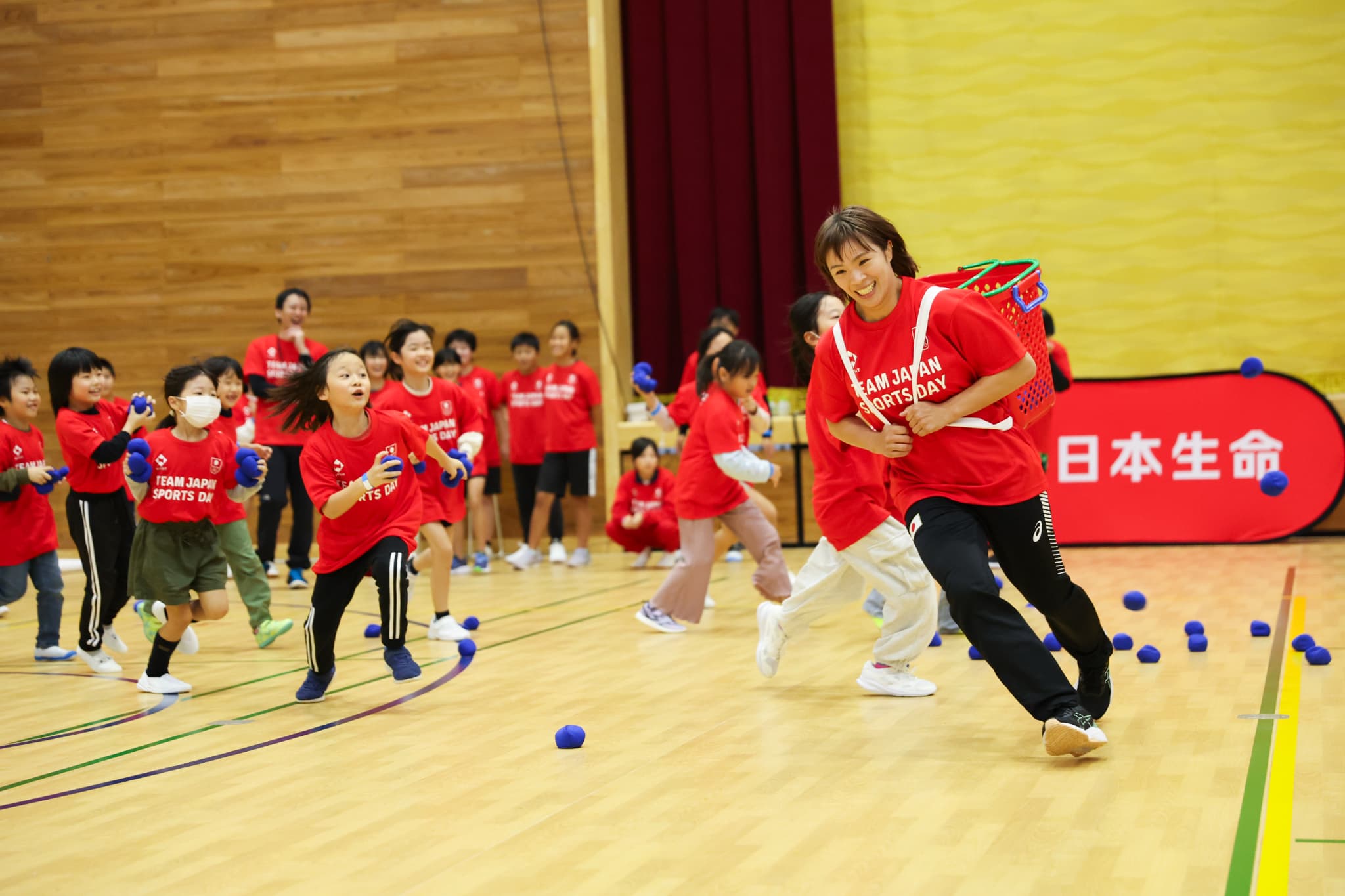 玉入れで子どもたちから逃げる金城梨紗子選手（写真：フォート・キシモト）