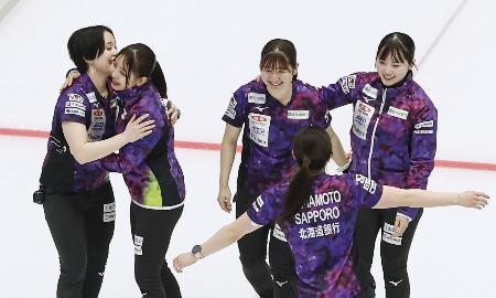 女子準決勝でロコ・ソラーレに勝利し、抱き合って喜ぶ北海道銀行の選手たち＝横浜ＢＵＮＴＡＩ