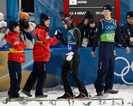 混合団体　２回目の飛躍を終え、丸山希（左から２人目）らとタッチを交わす二階堂蓮＝プレダッツォ（共同