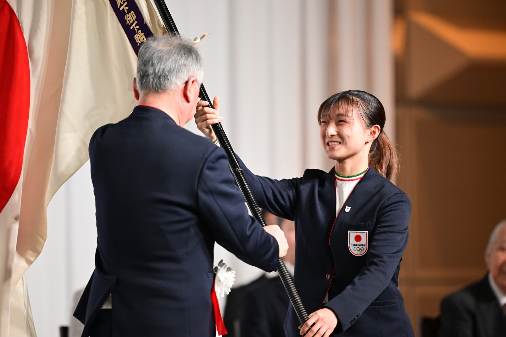 坂本花織旗手代行から伊東秀団長へ団旗を返還（写真：アフロスポーツ）