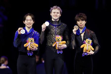 男子の表彰式でメダルを掲げる（左から）２位の鍵山優真、優勝のイリア・マリニン、３位の佐藤駿＝プラハ（共同）