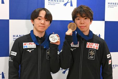 メダルを手に撮影に応じる鍵山優真（左）と佐藤駿＝３１日、羽田空港